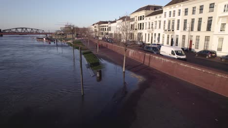 El-Agua-Del-Río-Ijssel-Invade-El-Pavimento-Del-Bulevar-Semblante-De-La-Ciudad-De-La-Torre-Hanseática-Con-Fachadas-Blancas-En-Zutphen,-Países-Bajos.