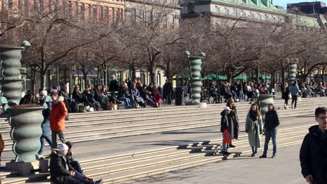 People-relax-on-sunny-day-in-park-Kungstradgarden-in-Stockholm,-static