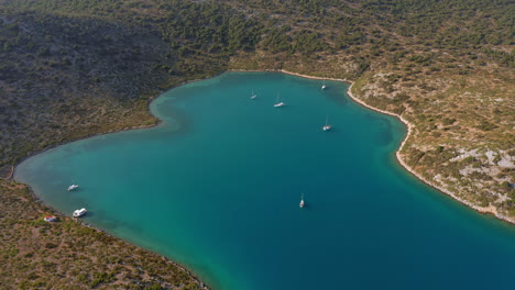 Panoramic-drone-shot-of-natural-harbour-of-Planitis-bay-in-Kira-Panagia-island,-Sporades,-Greece