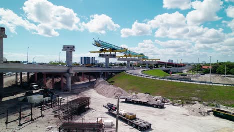 Rising-aerial-showcasing-launching-Gantry-machinery-over-Dolphin-Expressway,-Miami,-Florida,-USA