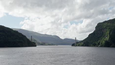 Zoom-Aéreo-Del-Dolly,-Empujando-Lentamente-A-Través-De-Las-Aguas-Abiertas-De-Laukelandsfjorden-Hacia-El-Puente-Dalsfjordbrua-En-Noruega.