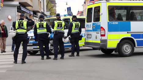 Police-officers-in-vests-stand-by-van-at-demonstration-in-Stockholm