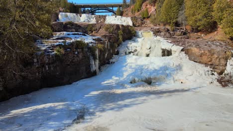 Felsiger-Fluss-Inmitten-Eines-Verschneiten-Waldes