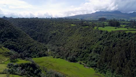 Clip-Cinematográfico-De-Drones-Sobre-Un-Cañón-Cubierto-De-Plantas-Y-Un-Río-En-Puichig,-Ecuador