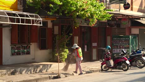 Worker-cleaning-streets-in-South-East-Asia-with-traffic