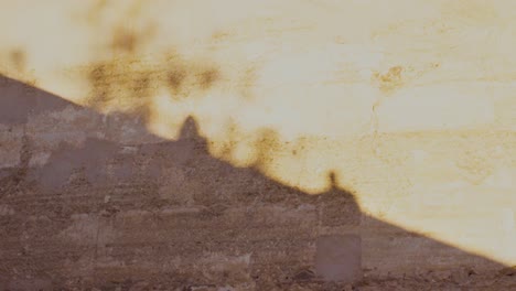 Silhouette-of-two-peoples-on-orange-ancient-wall