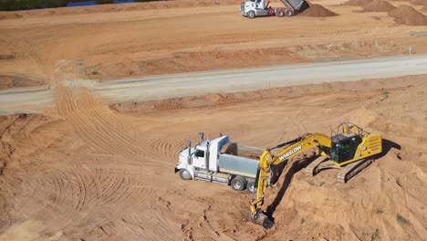 Yarrawonga,-Victoria,-Australia---8-March-2024:-Closeup-aerial-view-of-an-excavator-loading-a-truck-at-Silverwoods-Estate-in-Yarrawonga