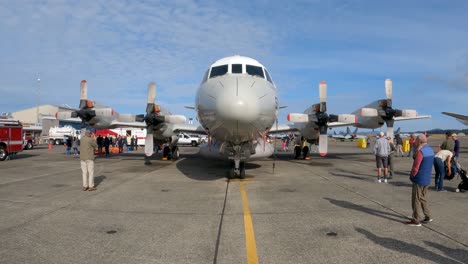 Propellor-based-plane-sitting-on-a-Navy-runway-with-tourists-all-around