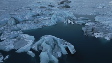 Flying-above-massive-ice-blocks,-spectacular-frozen-glacial-scenery