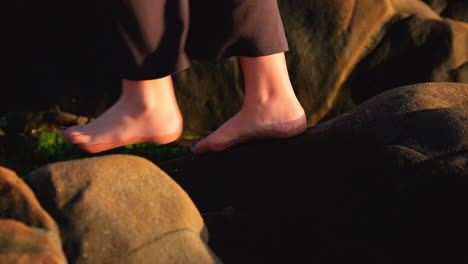 a-slow-motion-video-depicting-a-teenage-girls-feet-with-painted-toenails,-her-dog,-balancing-on-rocks-by-the-tidepool-on-a-pacific-coast-beach-in-california