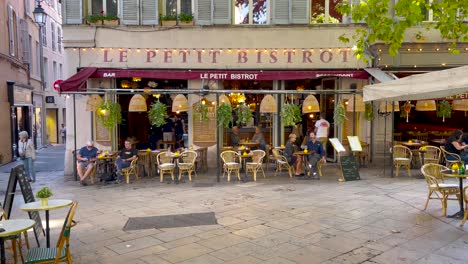 People-walk-by-cute-french-bistro-in-Aix-en-Provence,-France