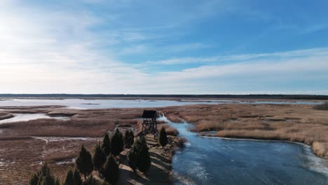 Torre-De-Observación-De-Aves-De-Riekstusala-En-El-Lago-Kaniera-Lapmezciems,-Sendero-De-Caña-De-Letonia-En-El-Fondo-Del-Parque-Nacional-De-Kemeri-Con-Pantanos-Y-Muchos-Lagos-Pequeños