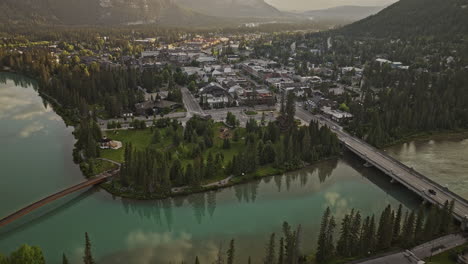 Banff-AB-Canada-Aerial-v20-birds-eye-view-flyover-Bow-river-across-the-town-along-the-Banff-avenue-capturing-quaint-townscape-and-forested-valleys-at-sunrise---Shot-with-Mavic-3-Pro-Cine---July-2023