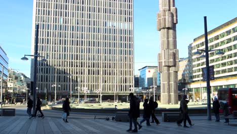 Red-city-bus-and-pedestrians-pass-by-square-Sergels-Torg-in-Stockholm