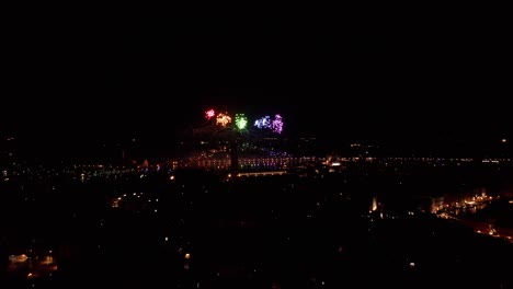 Colorful-fireworks-over-Venice-at-night,-illuminating-the-city's-silhouette,-aerial-view
