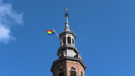 Bandera-Del-Arco-Iris-En-El-Campanario-De-Una-Iglesia-En-Amsterdam,-Holanda