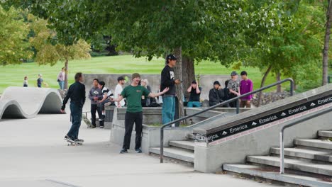 Eine-Gruppe-Junger-Zuschauer-Im-Teenageralter-Beobachtet,-Wie-Skater-In-Einem-Skatepark-Tricks-Machen