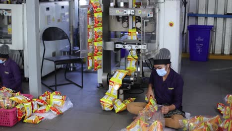 POV-Aufnahme-Der-Verpackungslinie-Aus-Der-Nähe,-Wo-Die-Verpackung-Von-Papdi-Gathiya-In-Der-Maschine-Erfolgt-Und-Pakete-Herauskommen-Und-Verpackt-Werden