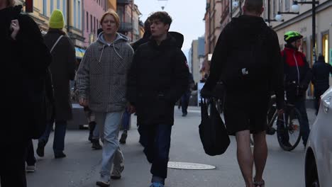 Static-slomo-of-two-boys-walking-among-others-on-street-in-Stockholm