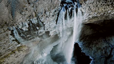 Aerial-cinematic-shots-filmed-in-4K-by-a-drone-capture-a-distinctive-glacier-formation-as-it-melts-and-cascades-water-onto-the-perilous-terrain-below