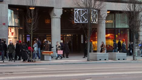 Weekend-shoppers-walk-in-front-of-department-store-NK-in-Stockholm