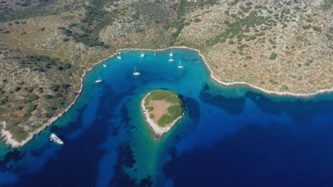 Drone-view-of-paradise-bay-of-the-island-of-Kira-Panagia-in-Sporades,-Greece-with-amazing-turquoise-and-emerald-crystal-clear-water