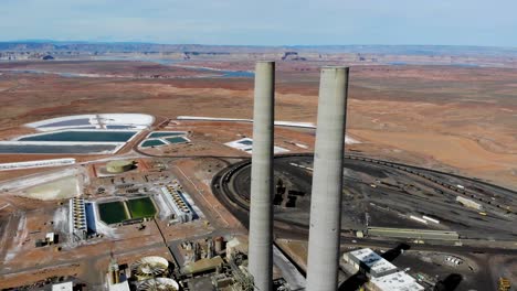 A-drone-shot-of-the-“Navajo-Generating-Station”,-a-massive-coal-fired-power-plant-and-industrial-complex-with-tall-stacks,-in-the-middle-of-the-desert-of-the-Navajo-Nation,-located-near-Page,-Arizona