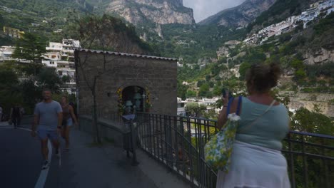 Turistas-Parados-Cerca-Del-Pintoresco-Acantilado-De-Montaña-En-Positano-Italia-Tembloroso,-4k