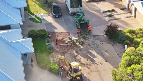 Yarrawonga,-Victoria,-Australia---6-March-2024:-Tree-workers-raking-leaves-while-the-stump-grinder-cuts-away-the-stump-in-a-suburban-street