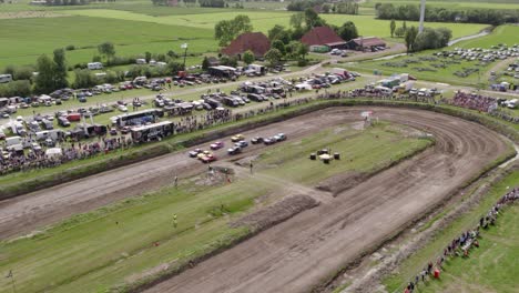 Aerial-view-of-old-cars-racing-on-dirt-track,-Friesland,-Netherlands