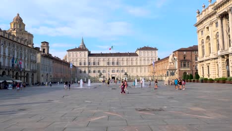 Wide-Slow-Motion-Shot-of-Italian-Flag-Blowing-in-the-Wind-with-Blue-Skies-over-Italian-Plaza