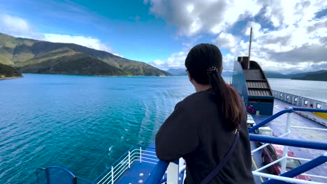 Mujer-Con-Cola-De-Caballo-Negra-En-El-Ferry-Bluebridge-Mirando-El-Agua,-Las-Colinas-Y-Las-Nubes-En-Queen-Charlotte-Sound