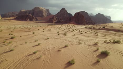 Tire-Tracks-in-Middle-Eastern-Wadi-Rum-Arabian-Desert-in-Jordan,-Aerial-Done-Tilt-up-Reveal