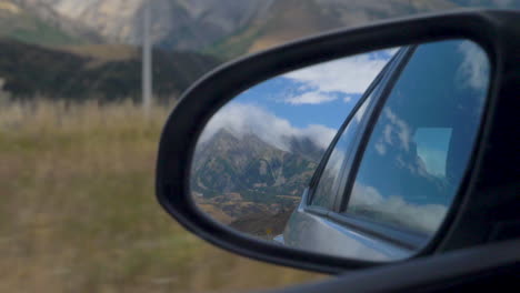 Toma-En-Cámara-Lenta-De-Una-Montaña-En-El-Espejo-Retrovisor-De-Un-Auto---Paso-De-Arthur,-Nueva-Zelanda