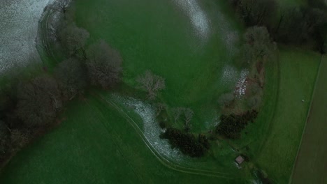 Cadbury-Castle-iron-age-hilltop-fort-aerial-drone-top-down-tilt-footage-during-a-sprinkling-of-snow