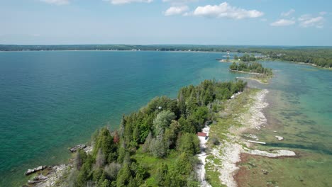 Vista-Aérea-De-Drones-De-Una-Casa-De-Luz-A-Orillas-Del-Condado-De-Door-Y-El-Lago-Michigan