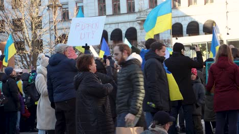People-protest-Russian-war-in-Ukraine-with-signs-and-flags,-Stockholm