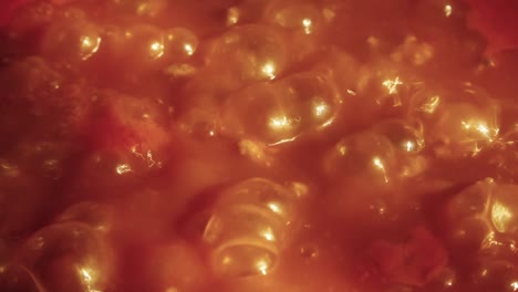 Close-up-of-boiling-tomato-sauce-creating-bubbles