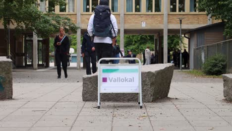 Voters-walk-by-polling-station-on-election-day-in-Stockholm,-Sweden