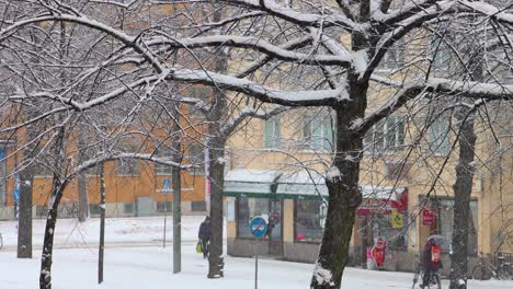 Pedestrians,-bicyclists-and-cars-move-on-snowy-Stockholm-street