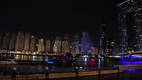 Dubai-Waterfront-Bei-Nacht,-Wolkenkratzer-In-Lichtern-Und-Wasserstraße-Von-Bluewaters-Island