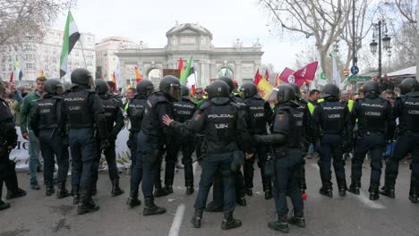 Polizisten-Stehen-Wache,-Als-Sich-Spanische-Landwirte-Und-Agrargewerkschaften-Auf-Der-Plaza-De-La-Independencia-Versammeln,-Um-Gegen-Unlauteren-Wettbewerb,-Agrar--Und-Regierungspolitik-Zu-Protestieren