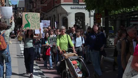 Mujer-Con-Signo-De-Dinosaurio-En-La-Marcha-De-Protesta-Por-El-Clima-En-Estocolmo,-Slomo