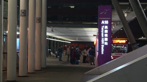 Gente-Esperando-El-Autobús-De-Conexión-Y-Viajeros-Que-Ingresan-Al-Edificio-De-La-Estación-De-Tren-De-Alta-Velocidad-A18-Taoyuan-Hsr,-Toma-De-Movimiento-Manual-En-La-Entrada,-Viaje-A-Taiwán