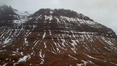 High-quality-footage-from-a-4K-drone-showcasing-aerial,-cinematic,-and-distinctive-perspectives-of-an-Icelandic-mountain-summit-amidst-challenging-weather-conditions