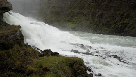 Gorgeous-majestic-waterfall-careens-over-river-rocks-forming-white-water-rapids