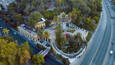 Neptune-Font-on-Saint-lucia-street-with-cars-and-surrounding-greenery,-shot-during-daylight,-aerial-view