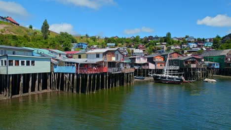 Coloridas-Casas-Tradicionales-Sobre-Pilotes-En-Castro,-Isla-De-Chiloé,-Paso-Elevado-De-Drones-4k-De-Chile