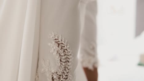 Close-up-wedding-dress-arm-sleeve-details,-bride-preparing-for-ceremony