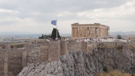 Grecia,-Atenas,-Vista-Aérea-De-La-Acrópolis-Con-Efecto-De-Vértigo-Dolly-Zoom,-Gente-Y-Bandera-Nacional-Griega-Frente-Al-Punto-De-Referencia